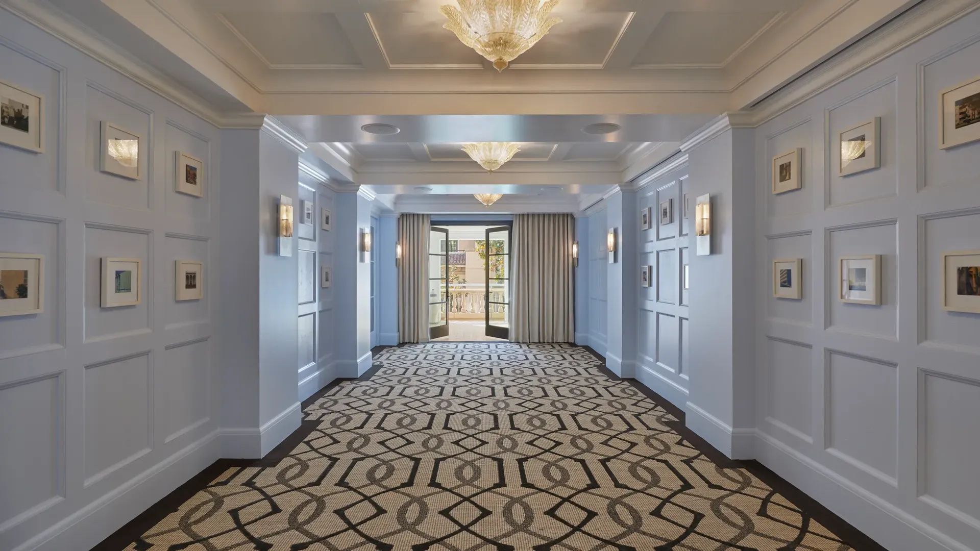 Canon Room foyer with blue paneled walls, framed art, and terrace doors.