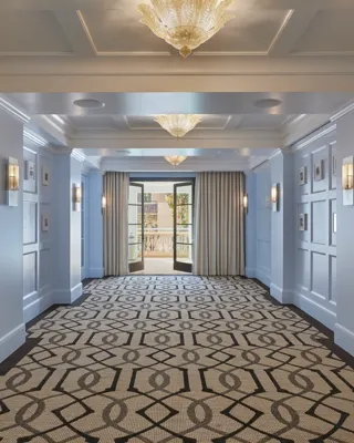 Canon Room foyer with blue paneled walls, framed art, and terrace doors.