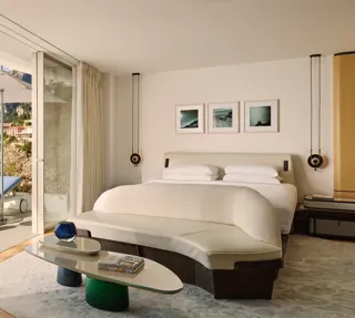 Chambre lumineuse avec terrasse, vue sur les montagnes et transat extérieur devant les baies vitrées.