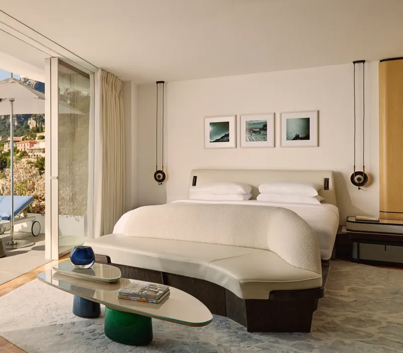 Chambre lumineuse avec terrasse, vue sur les montagnes et transat extérieur devant les baies vitrées.