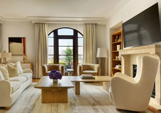 Dining space in The Maybourne Three-Bed Residence Wilshire with a large table, modern chairs, and floor-to-ceiling windows.