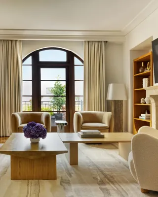 Dining space in The Maybourne Three-Bed Residence Wilshire with a large table, modern chairs, and floor-to-ceiling windows.