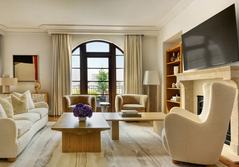 Dining space in The Maybourne Three-Bed Residence Wilshire with a large table, modern chairs, and floor-to-ceiling windows.