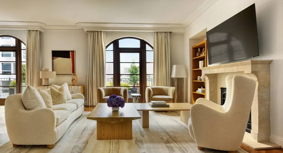 Dining space in The Maybourne Three-Bed Residence Wilshire with a large table, modern chairs, and floor-to-ceiling windows.