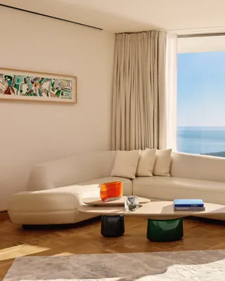 Bright white sofa in a minimalist living room with pale walls and soft natural light.