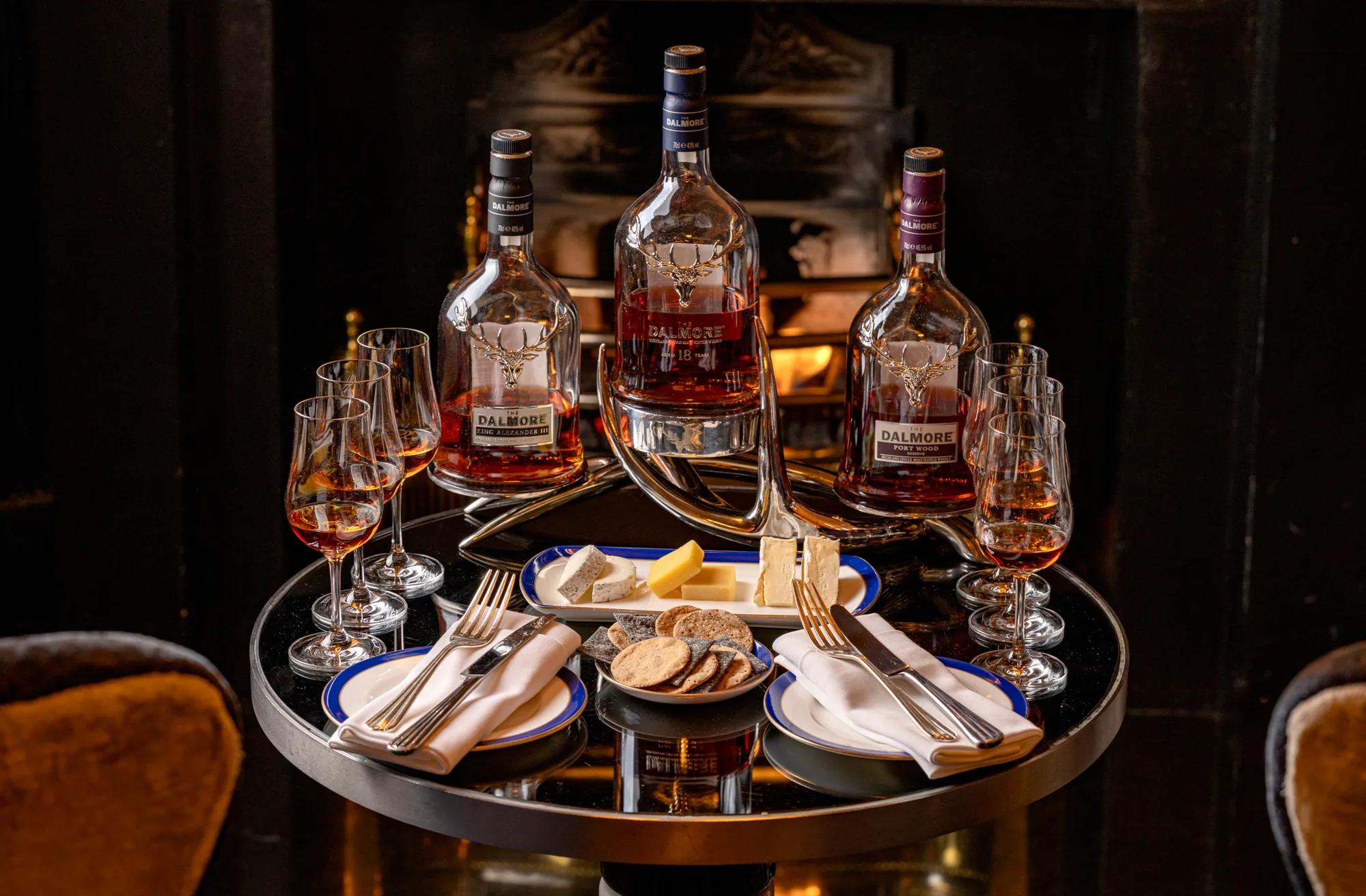 A couple of whisky bottles standing side by side, their labels and amber liquid clearly visible.