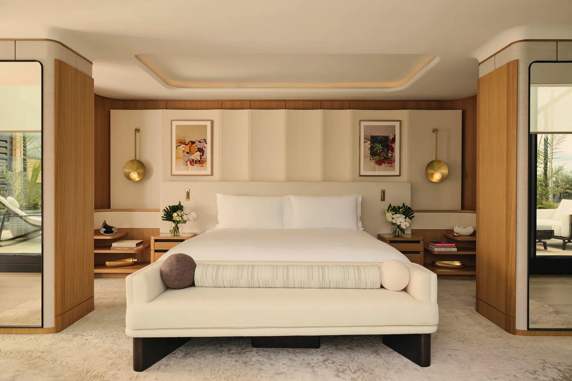 ChatGPT said:

A contemporary bedroom with a large bed, soft neutral tones, brass lighting, and wood accents opening onto a private terrace.