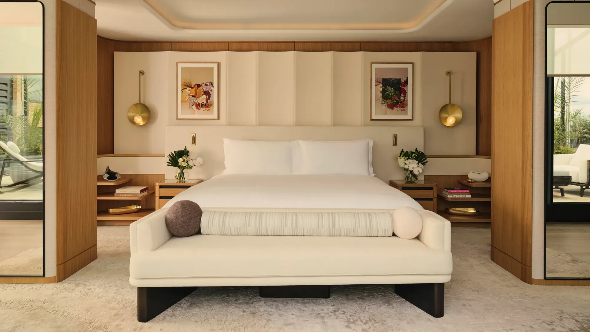 ChatGPT said:

A contemporary bedroom with a large bed, soft neutral tones, brass lighting, and wood accents opening onto a private terrace.