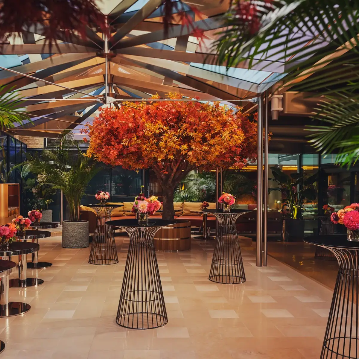 A spacious event venue with arranged cocktail tables and soft ambient lighting