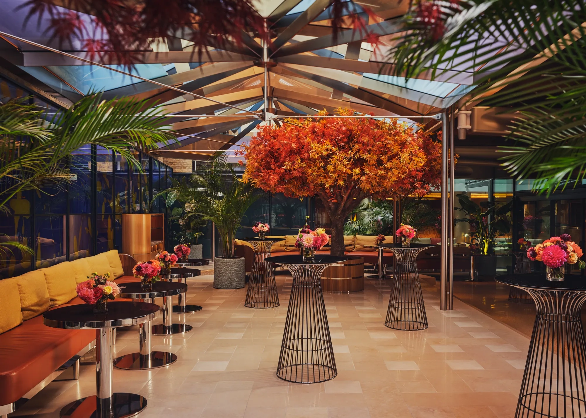 A spacious event venue with arranged cocktail tables and soft ambient lighting