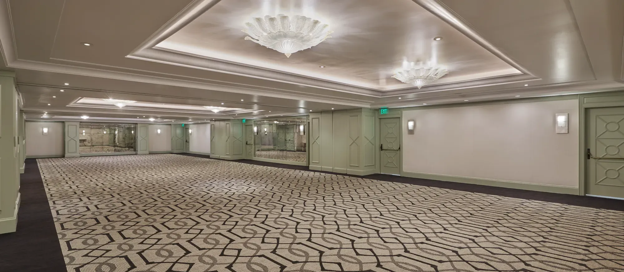 The Gallery event salon—expansive room with patterned carpet, mint doors, mirrors, and scalloped glass ceiling lights.