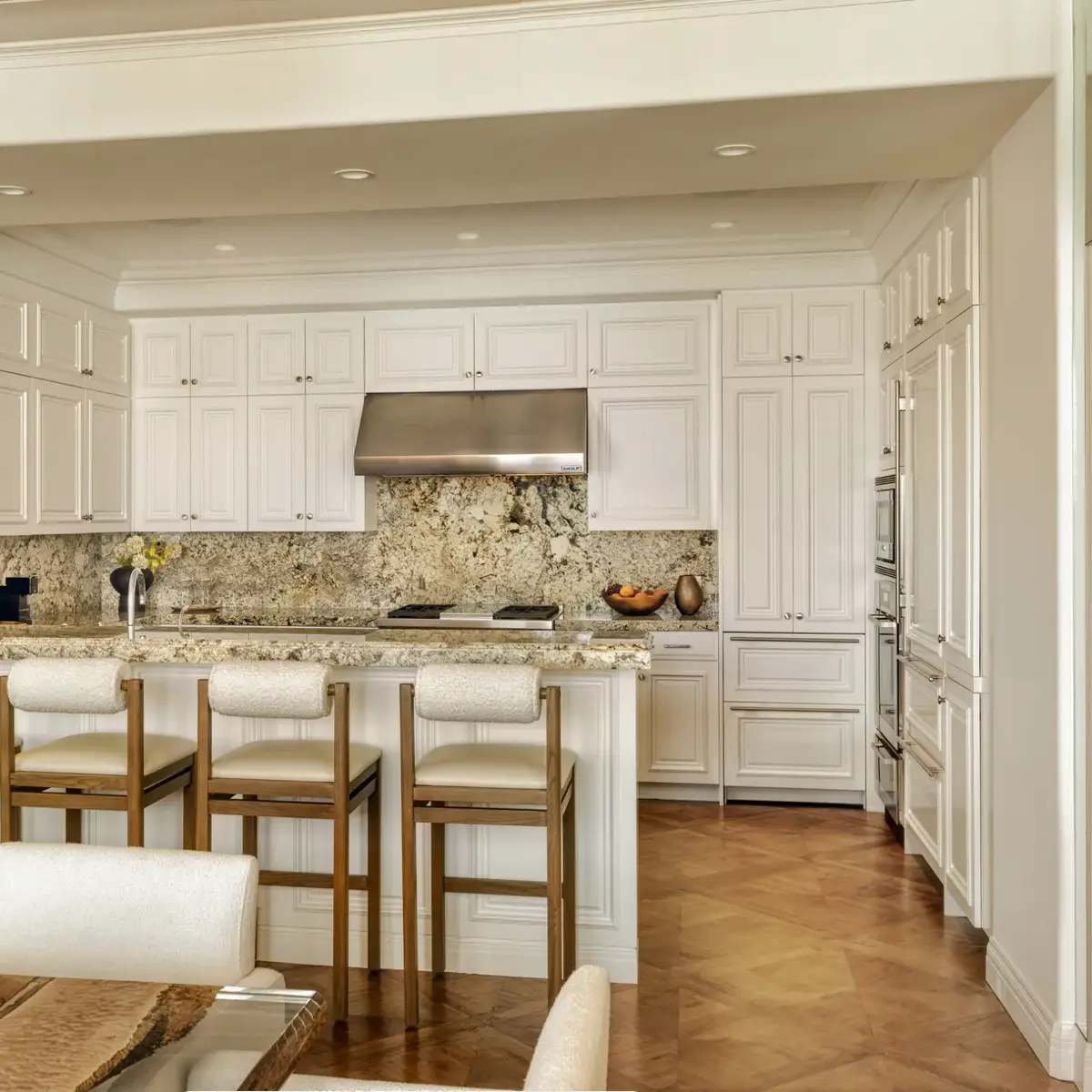 Spacious, contemporary living area in The Maybourne Three-Bed Residence Wilshire, featuring floor-to-ceiling windows, a plush sofa set, and a dining table with modern lighting.