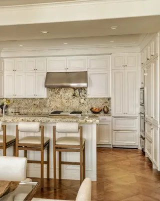 Spacious, contemporary living area in The Maybourne Three-Bed Residence Wilshire, featuring floor-to-ceiling windows, a plush sofa set, and a dining table with modern lighting.