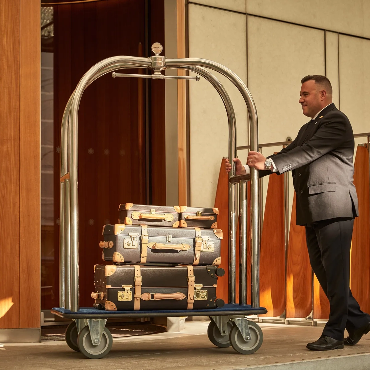 Person carrying suitcases while walking forward, holding one in each hand.