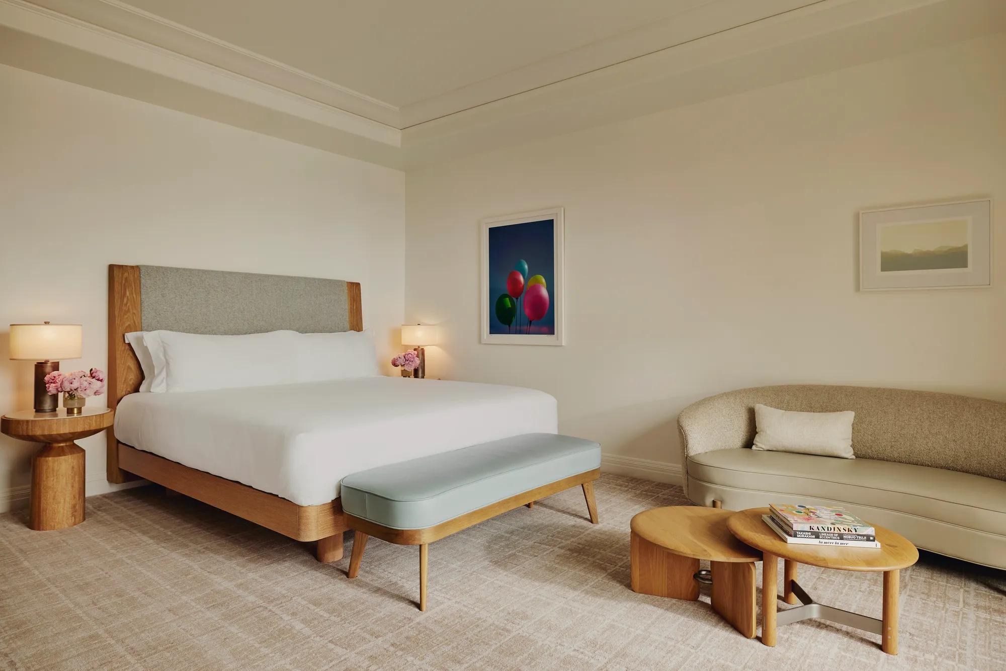 Detail of a king-size bed with plush white linens and textured headboard.