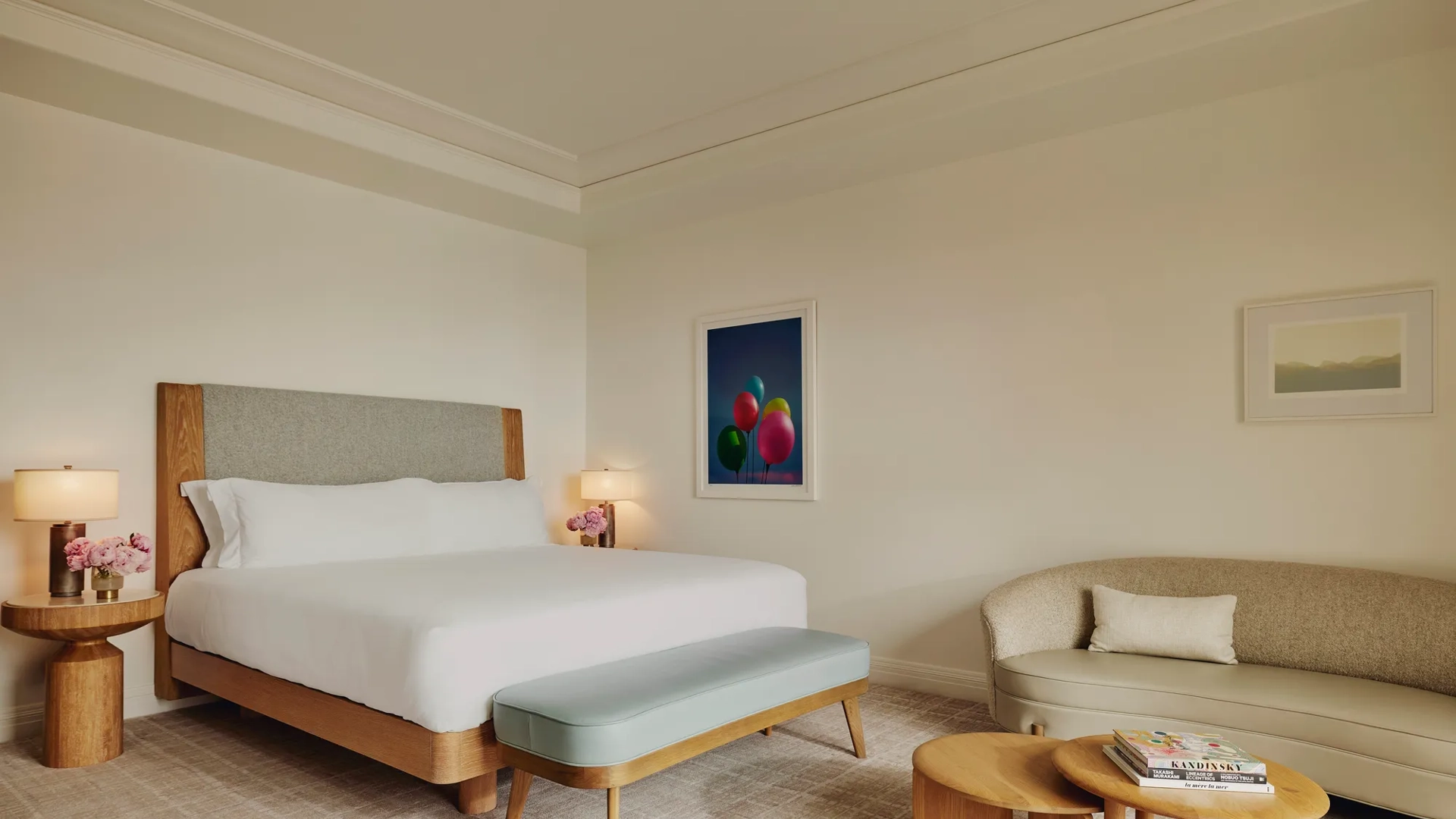 Detail of a king-size bed with plush white linens and textured headboard.