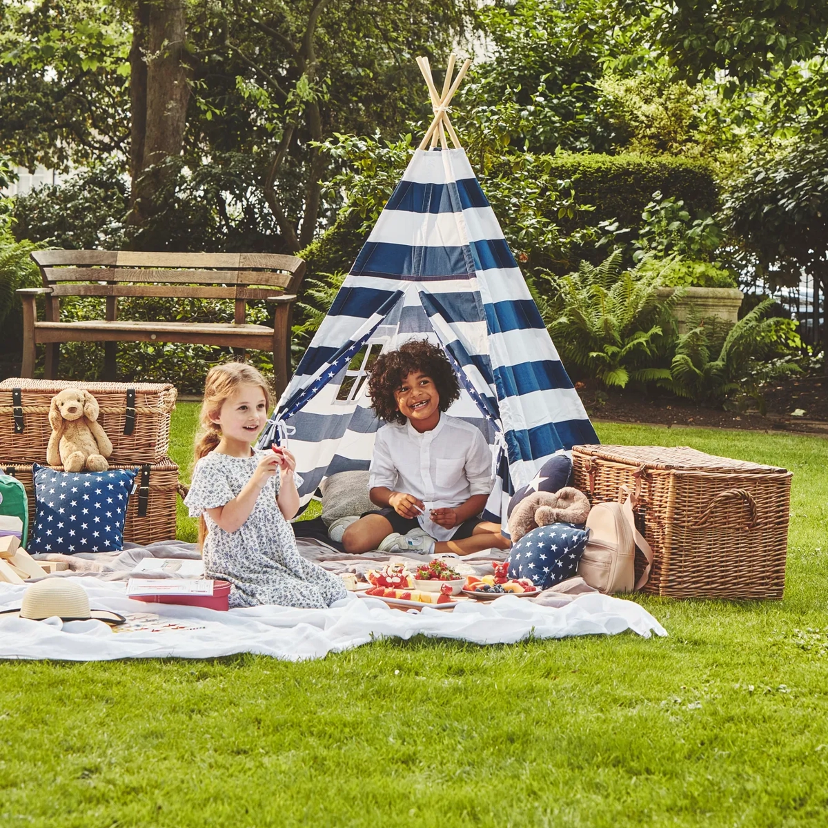 Children playing together outdoors, running and laughing in an open, sunny space.