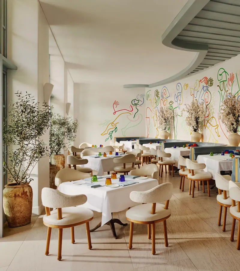 The Terrace dining room with curved banquettes and a colorful line-art mural along the wall.