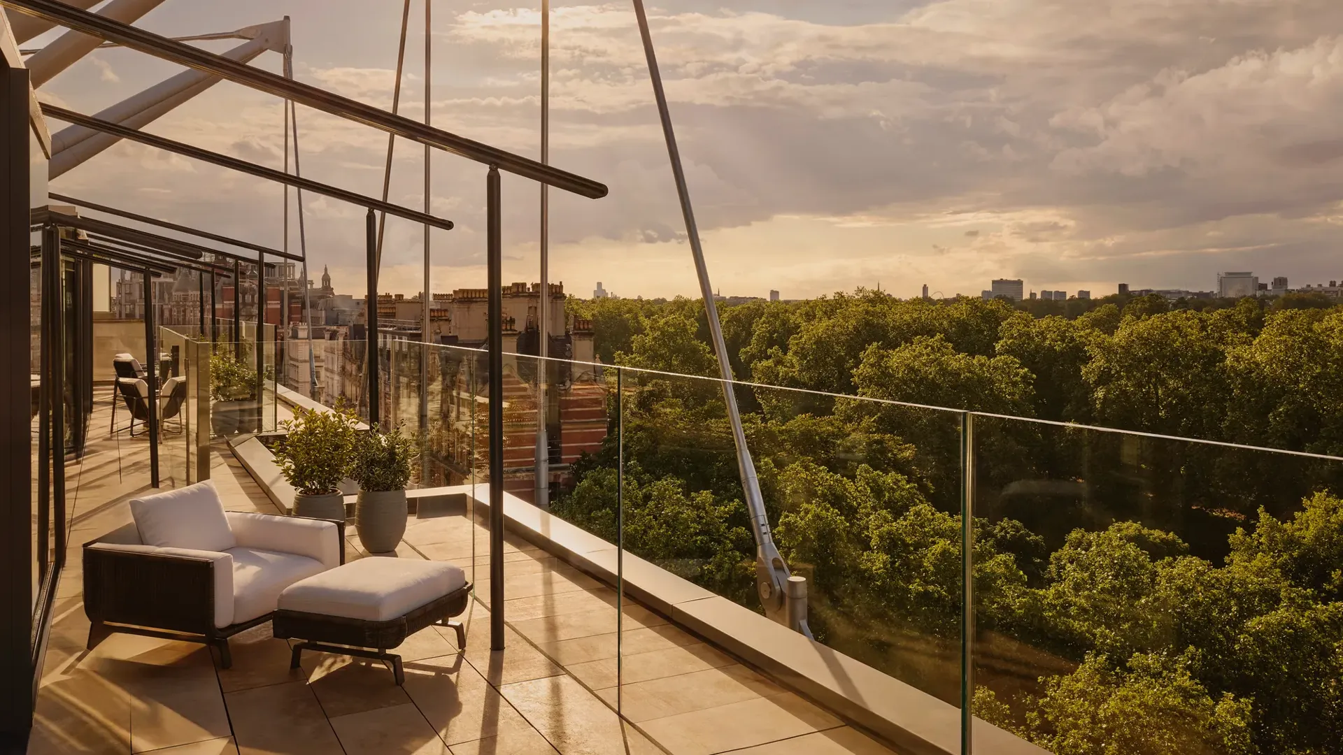 Rooftop terrace at sunset with lounge chairs and Hyde Park views.