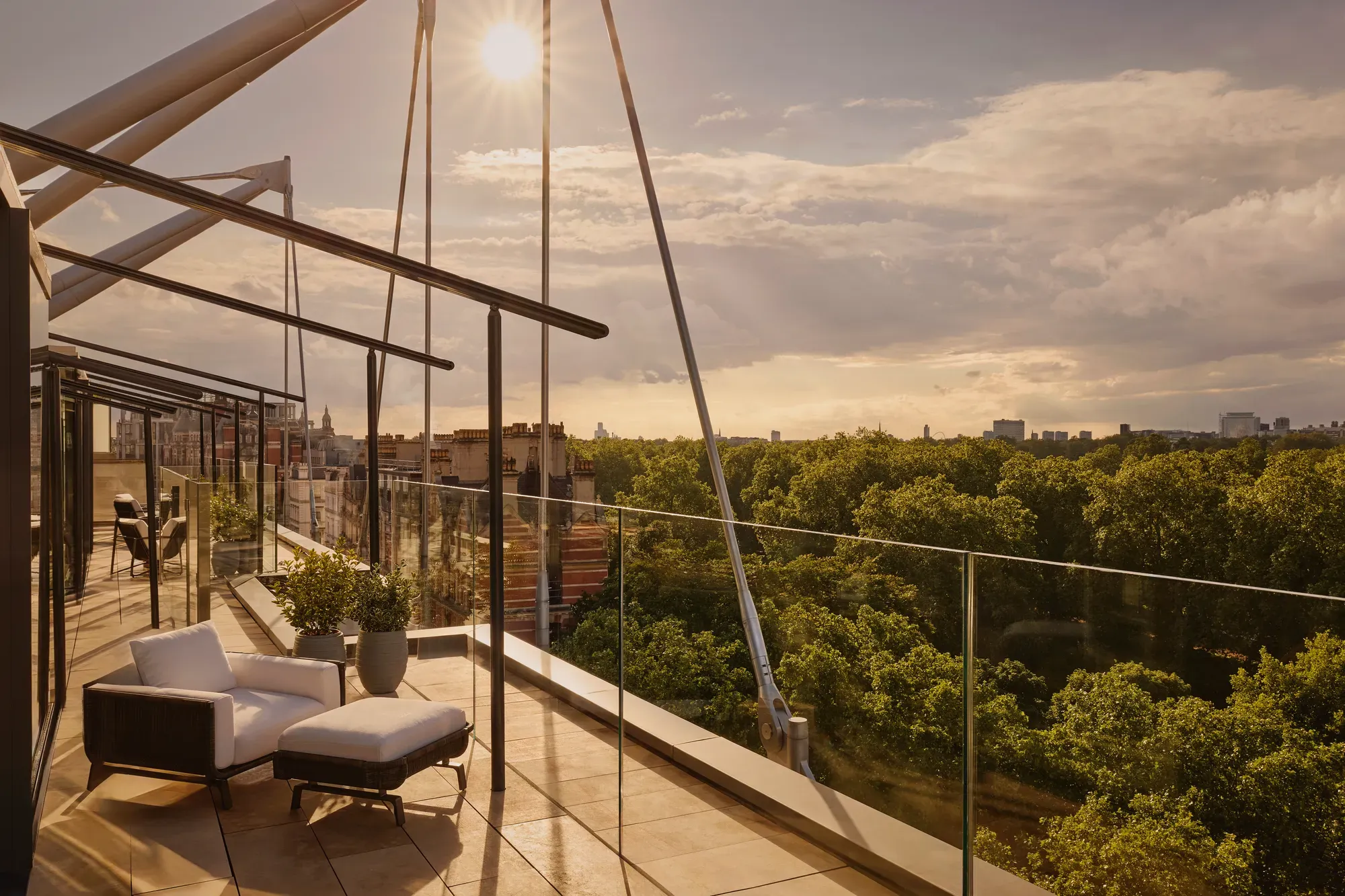 Rooftop terrace at sunset with lounge chairs and Hyde Park views.