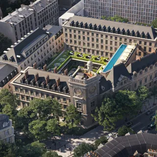 Aerial view of a historic city block with central courtyard garden, rooftop pool and surrounding stone buildings