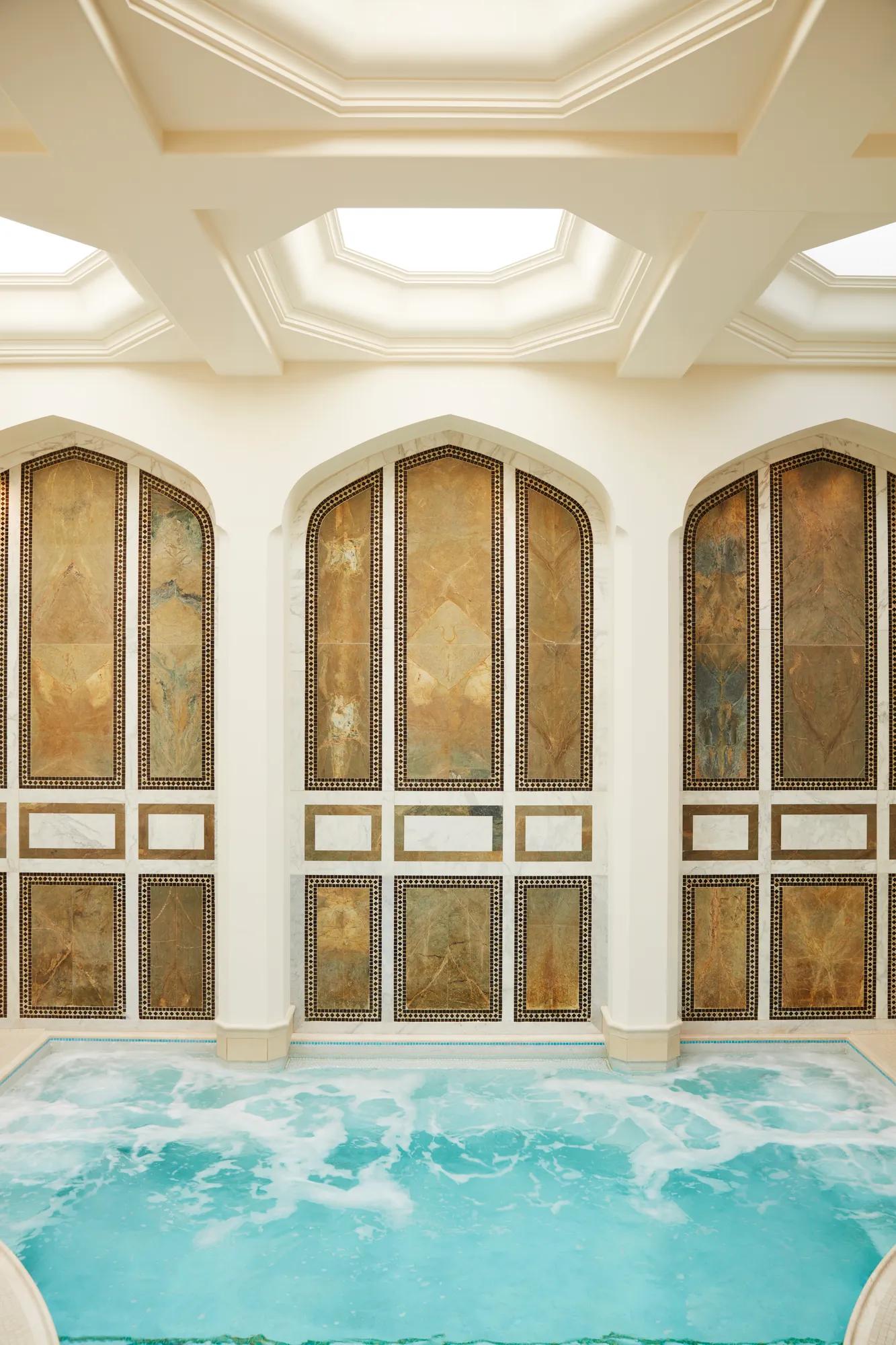 Indoor mineral pool at The Spa at The Maybourne Beverly Hills with arched marble walls and natural skylight ceiling.