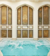 Indoor mineral pool at The Spa at The Maybourne Beverly Hills with arched marble walls and natural skylight ceiling.