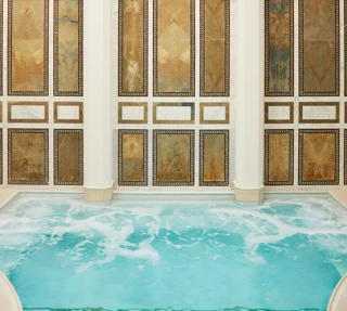 Indoor mineral pool at The Spa at The Maybourne Beverly Hills with arched marble walls and natural skylight ceiling.
