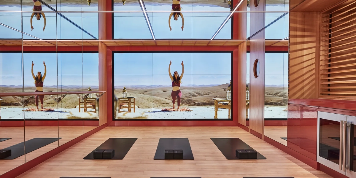 Bright studio space with six yoga mats arranged in two neat rows on a wooden floor