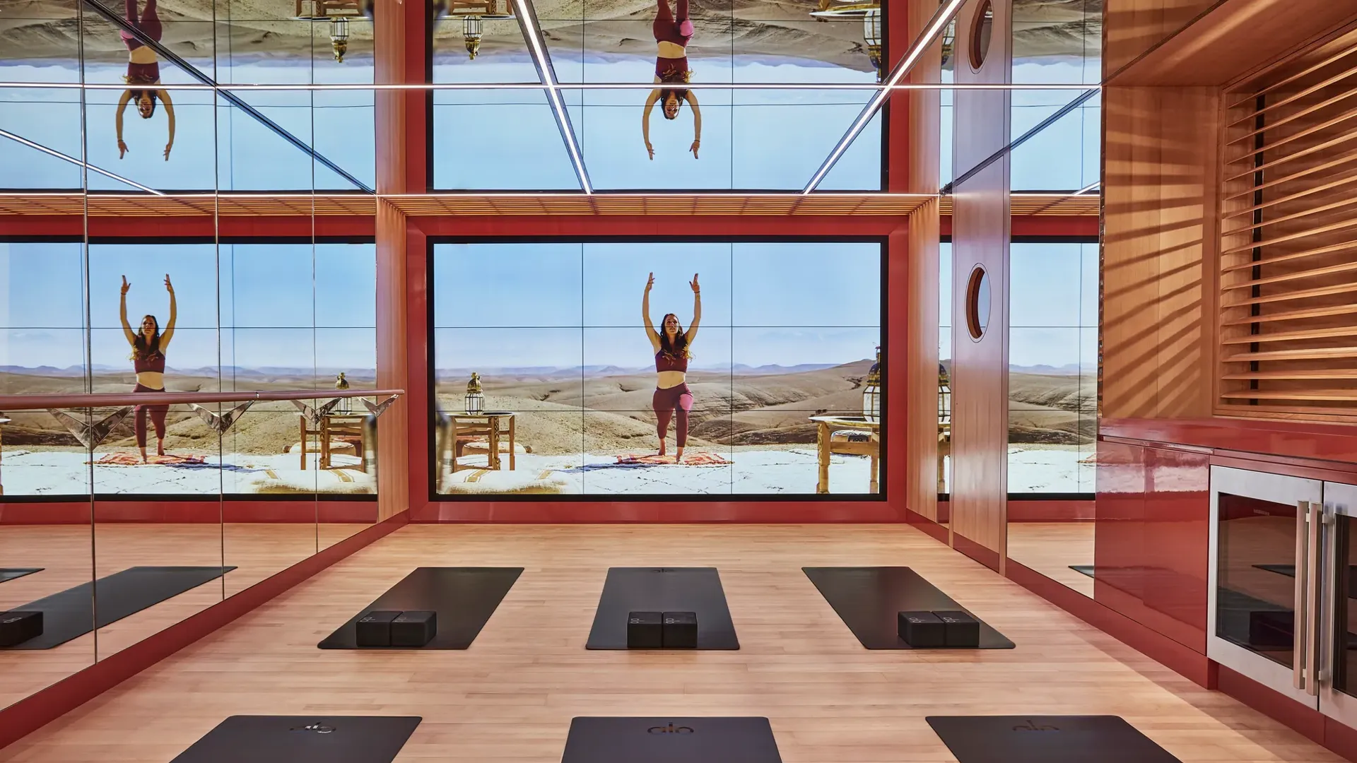 Bright studio space with six yoga mats arranged in two neat rows on a wooden floor