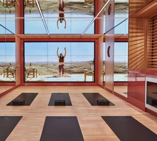 Bright studio space with six yoga mats arranged in two neat rows on a wooden floor