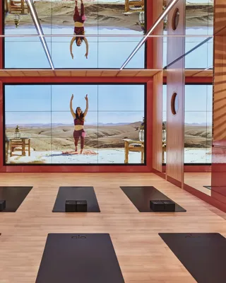 Bright studio space with six yoga mats arranged in two neat rows on a wooden floor