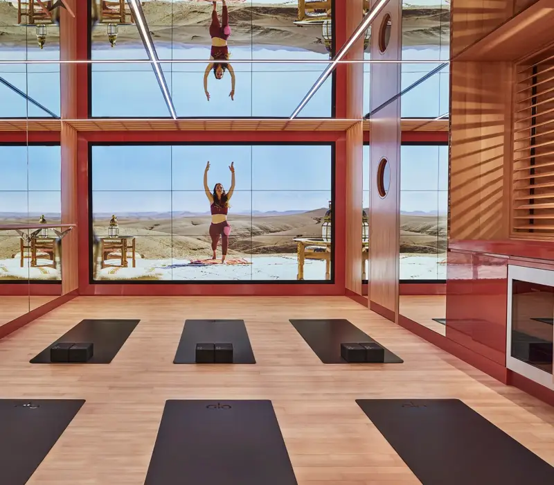 Bright studio space with six yoga mats arranged in two neat rows on a wooden floor