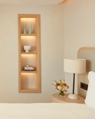 Elegant bedroom with built-in shelving, desk area, and adjoining lounge space.