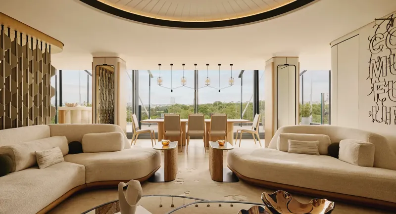 The Emory Penthouse lounge with curved sofas, sculptural accents, and panoramic Hyde Park views.