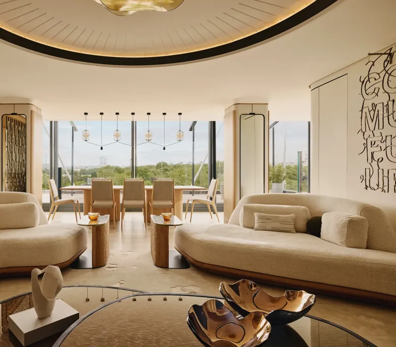 The Emory Penthouse lounge with curved sofas, sculptural accents, and panoramic Hyde Park views.