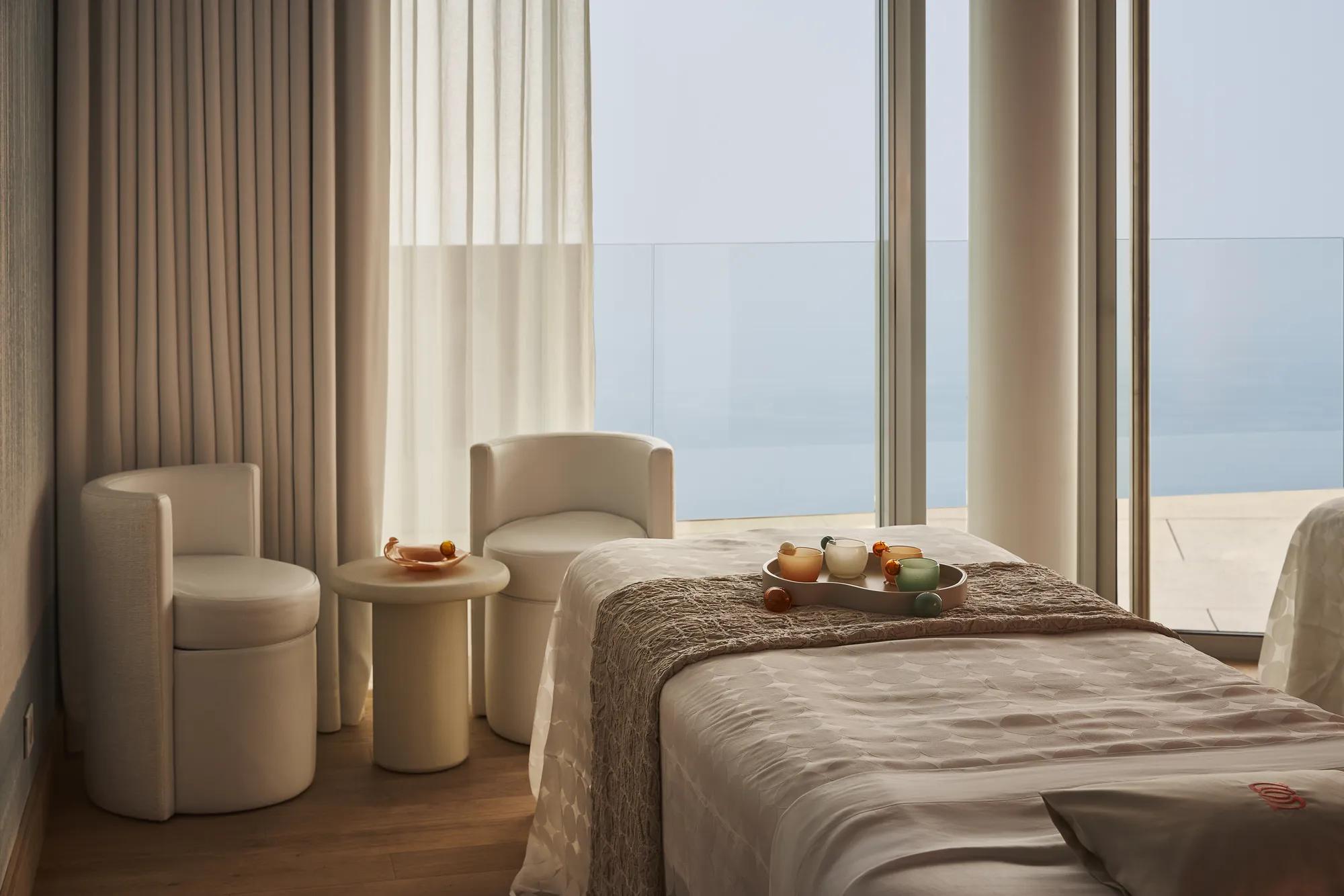 Treatment room with a padded therapy bed, soft lighting, and minimal décor.
