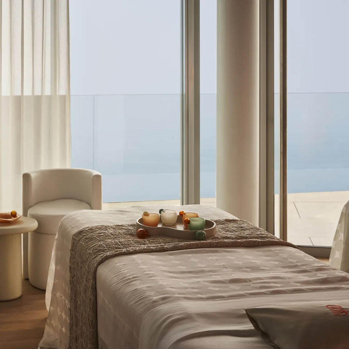 Treatment room with a padded therapy bed, soft lighting, and minimal décor.