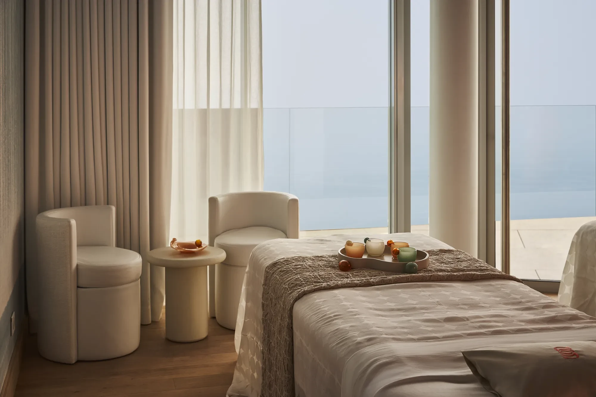 Treatment room with a padded therapy bed, soft lighting, and minimal décor.