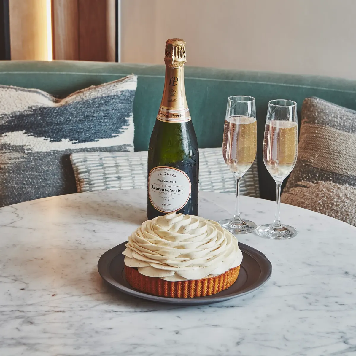 A polished marble table holding two filled champagne glasses, with soft light reflecting off the stone surface and bubbles rising gently in each glass