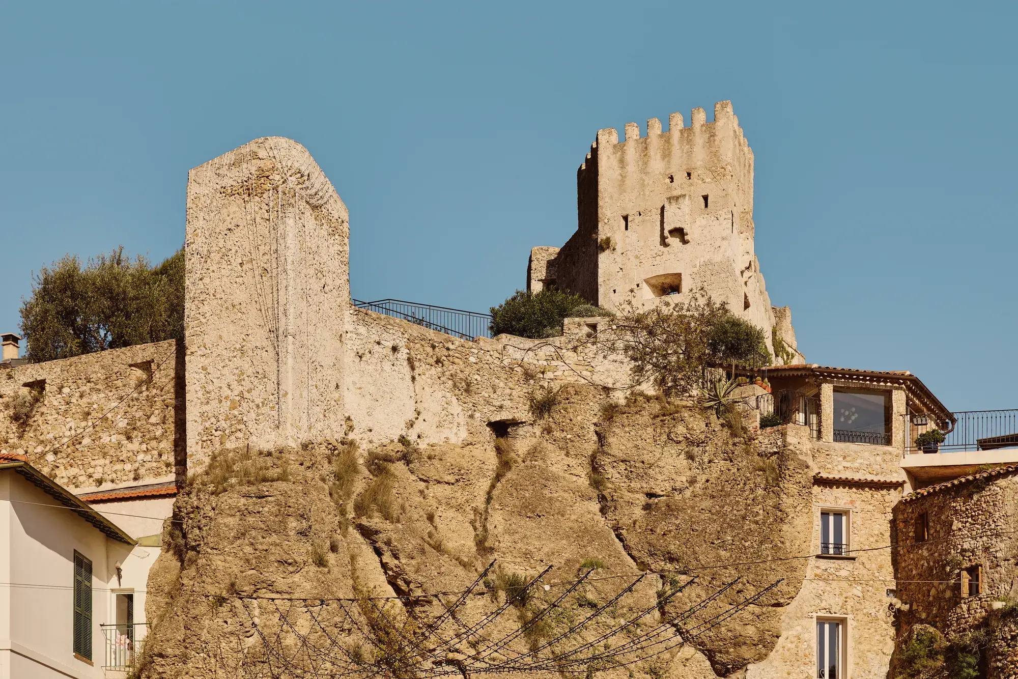 Ruines d’un château médiéval en pierre dominant les maisons du village, perchées sur une falaise roche