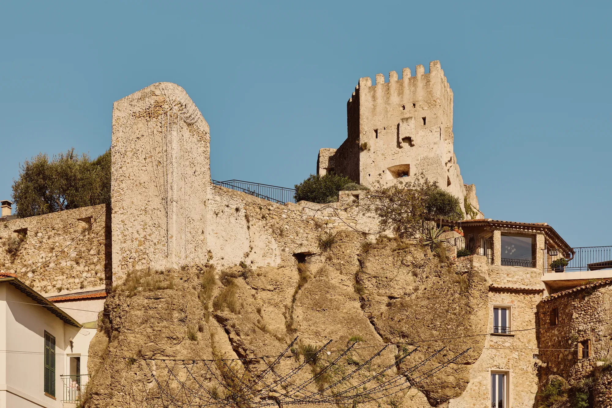 Ruines d’un château médiéval en pierre dominant les maisons du village, perchées sur une falaise roche