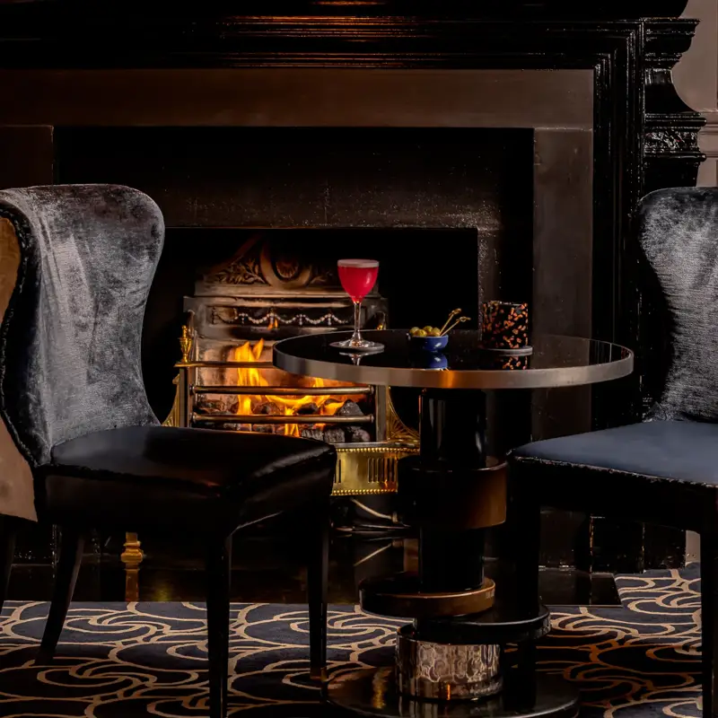 A spring cocktail at the Coburg Bar, presented in elegant glassware with seasonal garnishes and set against the bar’s warm, sophisticated backdrop.