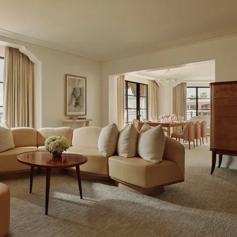 Garden Suite living room with sofa, armchairs, and French doors opening to terrace.