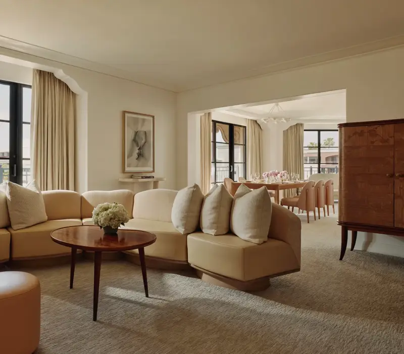 Garden Suite living room with sofa, armchairs, and French doors opening to terrace.