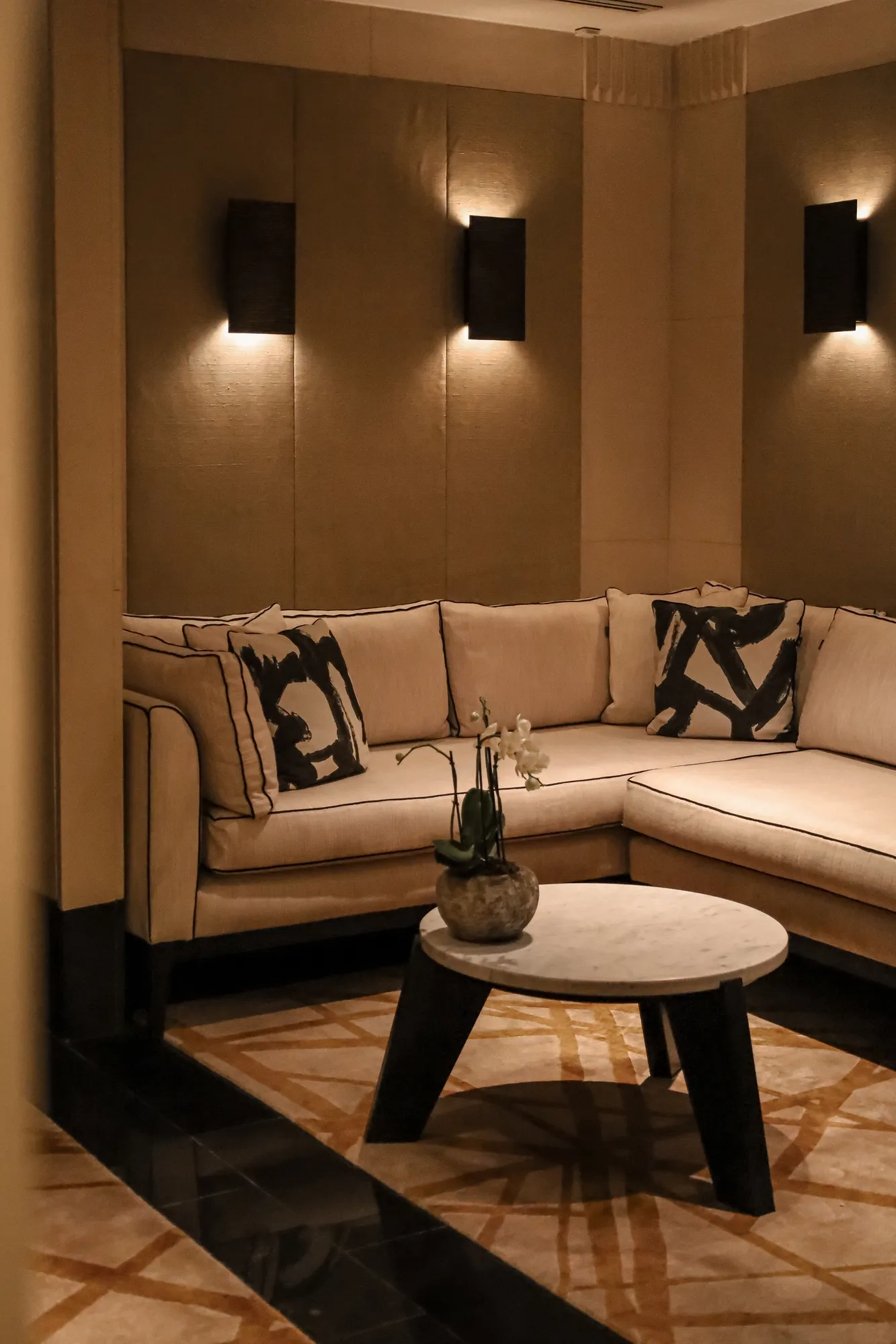Cozy seating area featuring a beige sofa, light ambient lighting, and simple decorative accents.