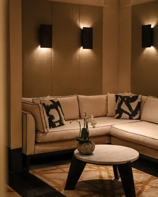 Cozy seating area featuring a beige sofa, light ambient lighting, and simple decorative accents.