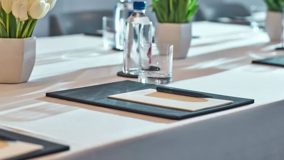 Close-up of Canon Room meeting table with tulips, notepads, and water bottles.