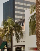 Rodeo Drive boutiques—Frette, Brioni, and Philipp Plein—set among palms and mixed modern architecture.