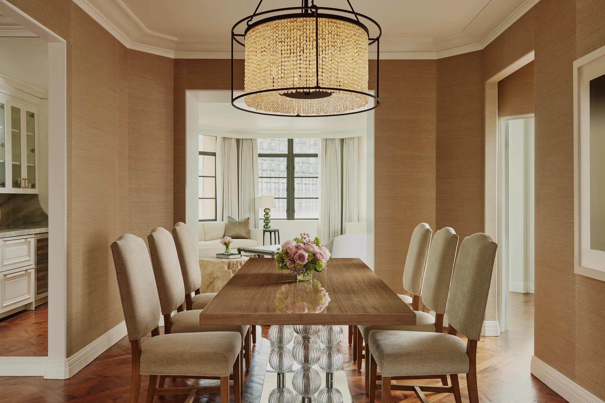 Dining area in the Beverly Three-Bedroom Residence, featuring a large round table, contemporary chairs, and soft lighting.